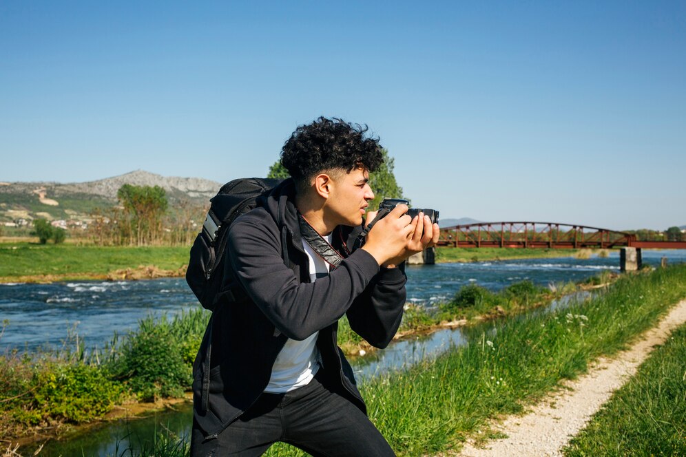 homem tirando fotografia num campo